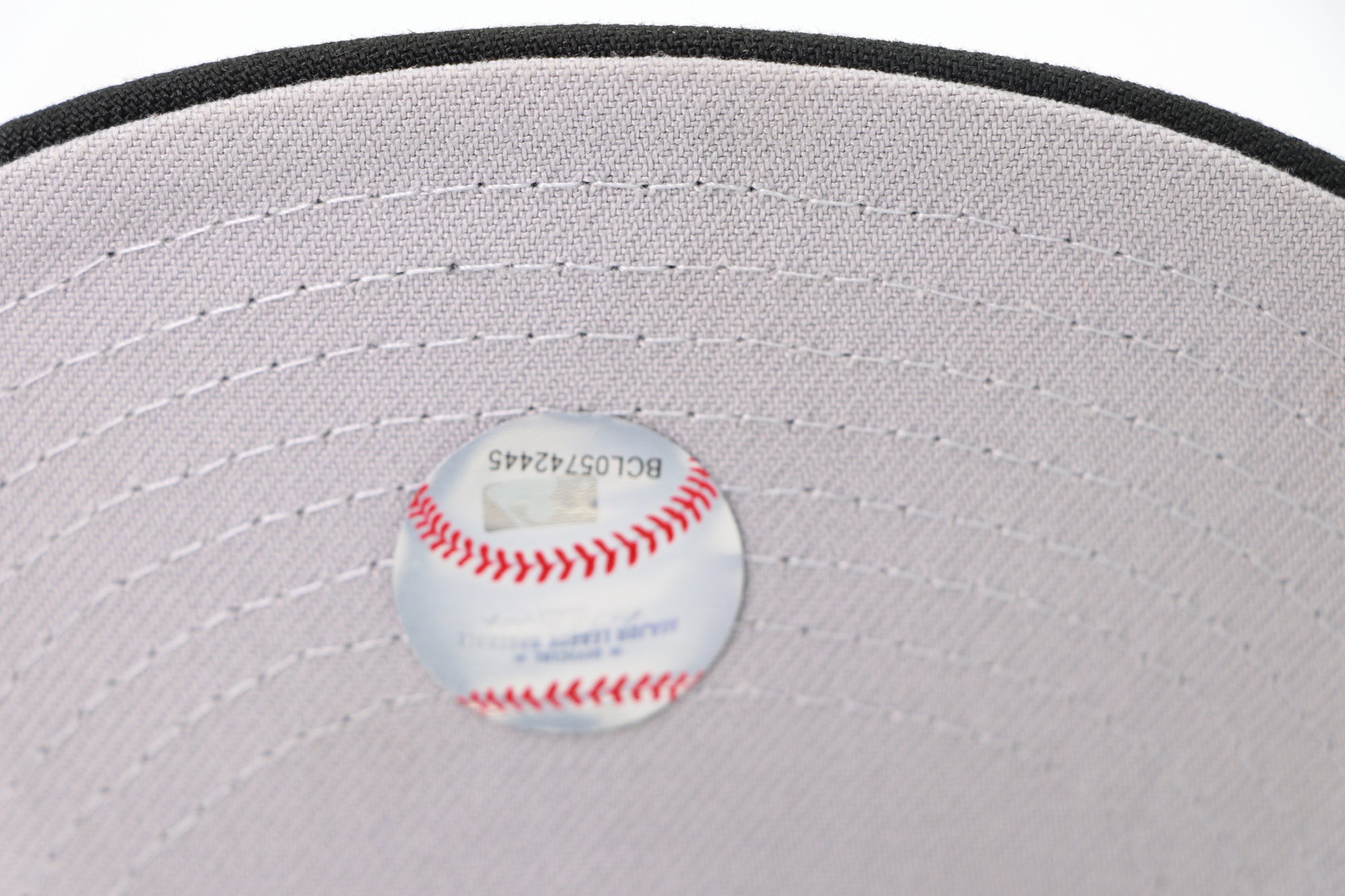 Baseball on a gray cap with visible stitching