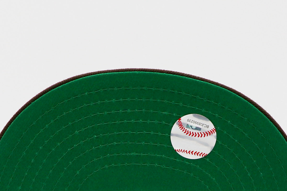 A fitted hat with the San Diego Padres logo, featuring a two-tone brown and yellow design with a green under visor.