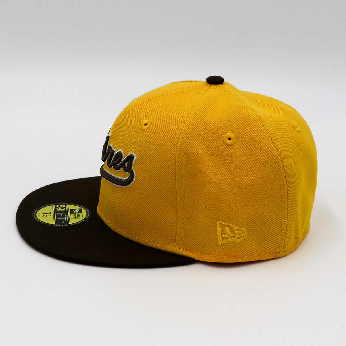A fitted hat with the San Diego Padres logo, featuring a two-tone brown and yellow design with a green under visor.