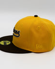 A fitted hat with the San Diego Padres logo, featuring a two-tone brown and yellow design with a green under visor.