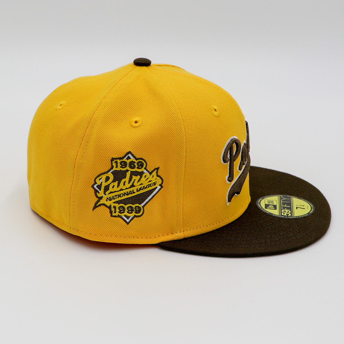 A fitted hat with the San Diego Padres logo, featuring a two-tone brown and yellow design with a green under visor.