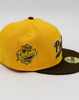 A fitted hat with the San Diego Padres logo, featuring a two-tone brown and yellow design with a green under visor.