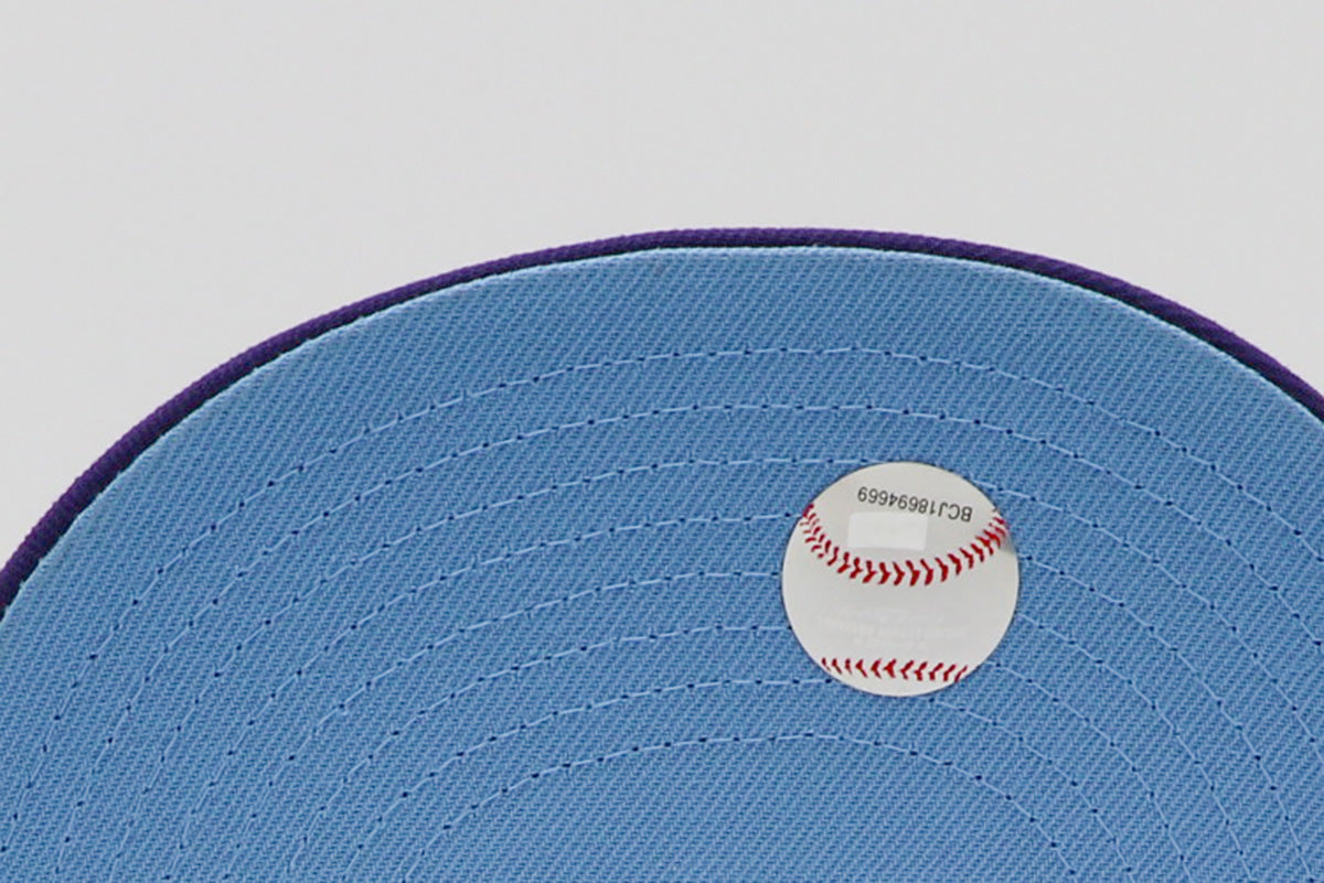 A purple fitted hat with metallic patches featuring the San Diego Padres logo.