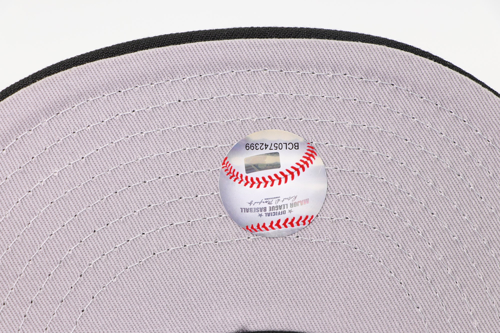 Baseball on a gray cap with visible stitching details